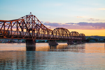 Fototapeta premium Sunset Over Historic Train Bridge in Fort Pierre, South Dakota with Train on Missouri River