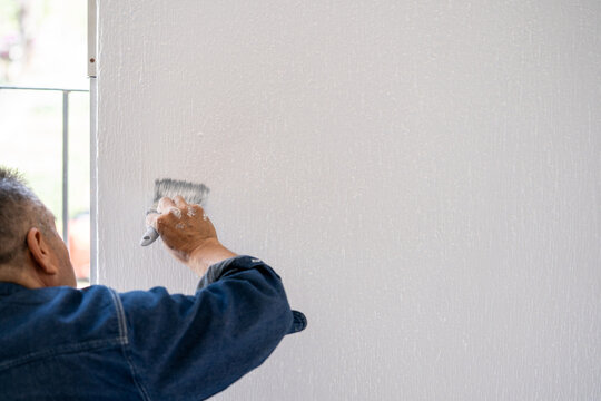 hombre pintando la pared de blanco con brocha con espacio para texto