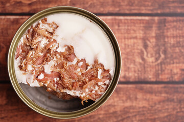 Canned meat dish with a layer of fat on wooden table