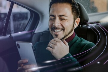 Happy man using his smartphone in the car