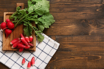 Board with fresh radishes on wooden background