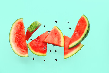 Flying pieces of fresh watermelon and seeds on turquoise background