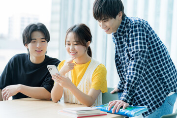 スマホを見ながら話す学生たち【撮影協力:スカパー東京メディアセンター】