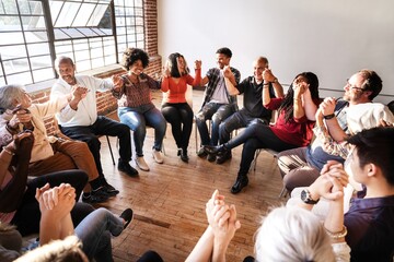 Diverse group in a circle holding hands, showing unity and connection, sharing a moment of...