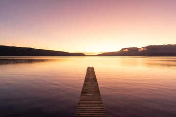 Lake at sunrise with golden light and reflection