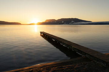 Lake at sunrise with golden light and reflection