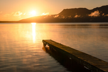 Lake at sunrise with golden light and reflection