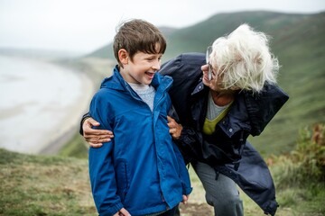 Joyful elderly woman with young boy outdoor nature. Caucasian grandmother and grandson enjoying a...