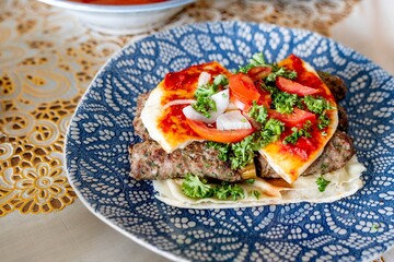 Delicious Turkish pizza with fresh tomatoes, parsley, and onions. Turkish pizza topped with vibrant vegetables. Enjoy Turkish pizza with fresh ingredients. Mediterranean food with pita bread.