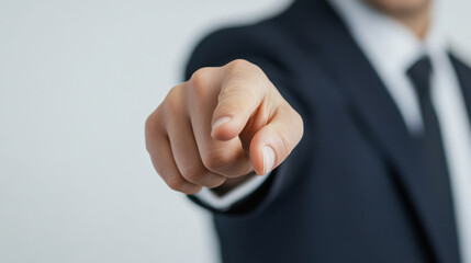 business man in suit points directly at viewer, conveying authority and confidence. focus is on his hand, emphasizing gesture