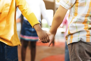 Obraz premium Children holding hands, showcasing unity and friendship. Kids holding hands, emphasizing connection and togetherness. Diverse children holding hands, symbolizing unity and friendship in school.