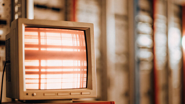 Abstract data patterns on glowing computer monitor in dimly lit room, symbolizing surveillance and data collection, with faint outlines of server racks in background.