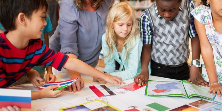 Diverse group of children engaged in creative activity, drawing and reading together. Multicultural kids collaborating, learning, and sharing ideas in a classroom. Elementary school kids in classroom.