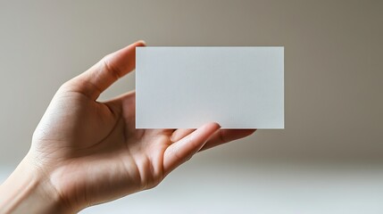 Obraz premium An open hand holds a blank business card, modern and unique, against a white background