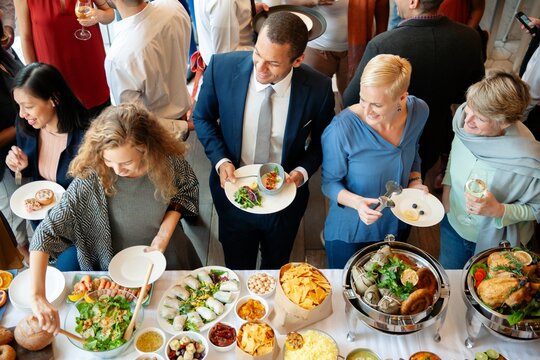 Diverse group enjoying buffet. Diverse people chatting and eat buffet. Social gathering with a variety of cuisines and appetizer. Business colleagues eat buffet. Catering at business company event