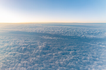 Beautiful orange and pink sunrise over the clouds, view from the plane.
