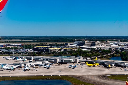 Orlando, FL, USA - March 18, 2025
- The runway and buildings of Orlando International Airport (MCO) during the middle of the day