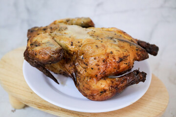 Roasted chicken whole on white plate