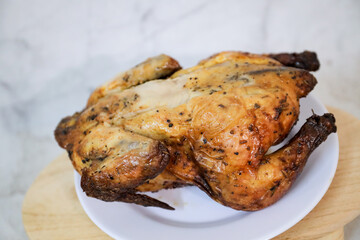 Roasted chicken whole on white plate