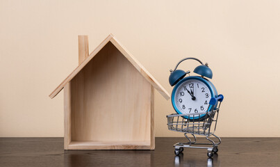 Symbolic wooden house and alarm clock