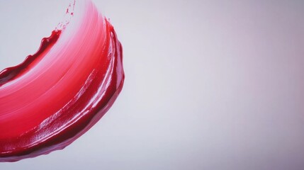 A bold red brushstroke curves gracefully across a light background, showcasing the artistry and fluidity of paint application