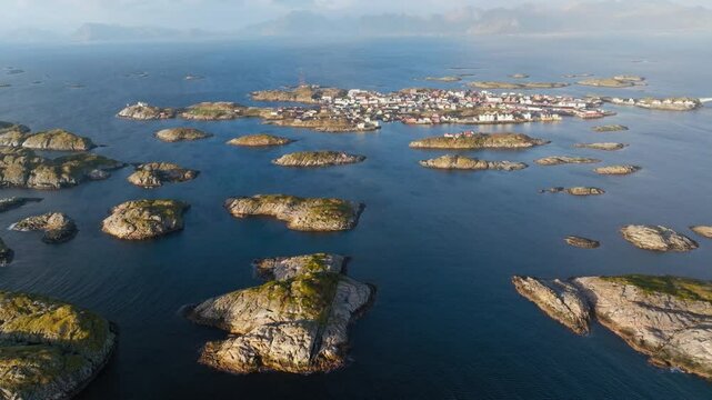 Vakthusoya, Lilje Vakthusoya, and Ramnbergholmen islands, Lofoten, Norway, bathed in morning light, aerial trackign across islets