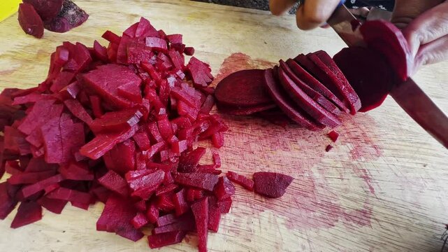 Close up of female hands in gloves cutting beet on kitchen board