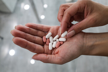 Women hand holding pills pick a one pill of lot © Photo Wizzzard