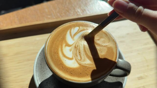 mix cup of coffee flower drawing on wooden table Trainee woman barista stir cocoa prepare for practice to draw latte art on surface of mocha coffee, beautiful flower pattern sample.