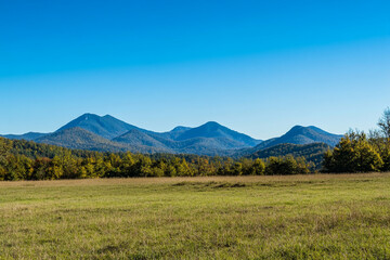 Fototapeta premium Vibrant mountains stretch across a clear blue sky in a serene landscape during late morning hours
