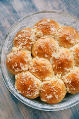 Glass dish with ruddy donuts sprinkled with grated garlic on the table