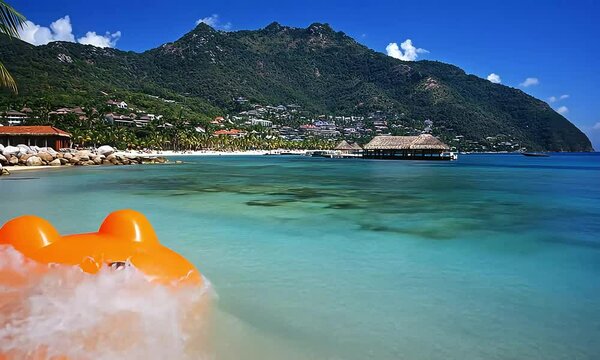 Happy frog float on tropical beach, mountains background, summer vacation