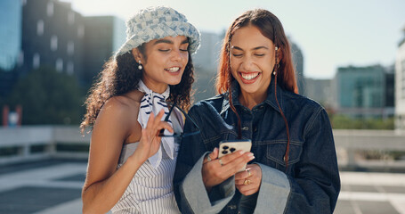 Women, friends and laughing with phone in city for social media, reading funny blog and bonding...