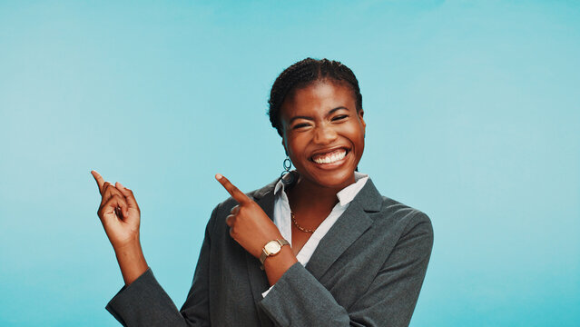 Business, pointing and black woman in studio, portrait and vacancy announcement on blue background. African person, model or consultant with hand gesture, space and about us with info or coming soon