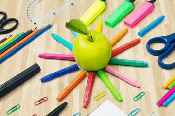 Green apple with multicolored stationery