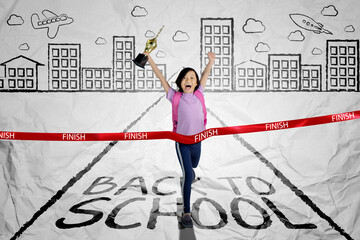 Happy schoolgirl crossing the finish line