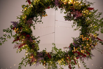 A stunning hanging floral wreath with greenery and fairy lights