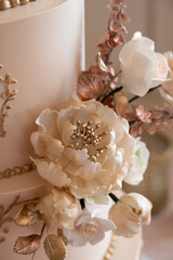 Wedding cake adorned with intricate sugar flowers and gold details