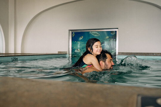 father and daughter in indoor swimming pool