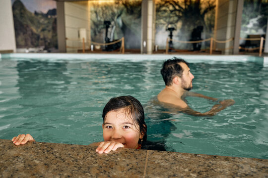 father and daughter in indoor swimming pool