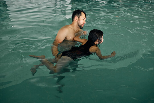 father and daughter in indoor swimming pool