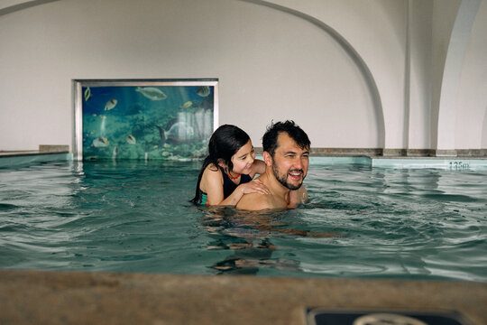 father and daughter in indoor swimming pool