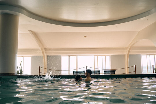 father and daughter in indoor swimming pool