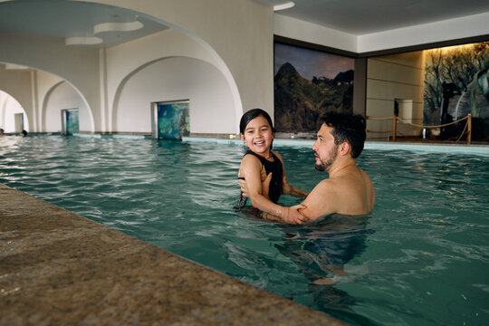 father and daughter in indoor swimming pool