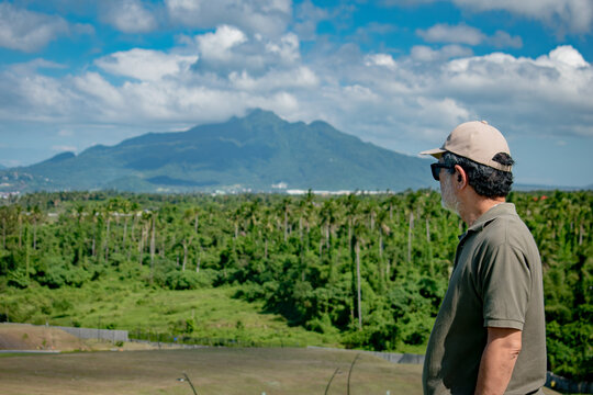 Senior Man Looking at Land being developed with view of Mount Makiling