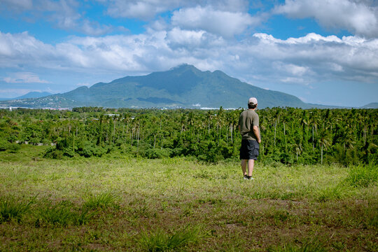 Senior Man looking at view of Mount Makiling and coconut tree grove