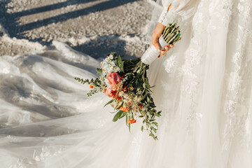 Detail Shot of Bride with her Bouquet, floral wedding dress, and train