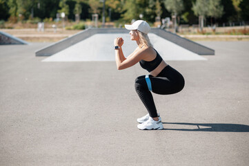 Young caucasian woman doing squats using rubber resistance band