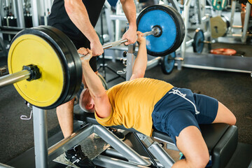 Athlete Confidently Performing Bench Press with Trainer's Support