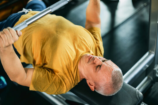 Muscular man performing a bench press in the gym